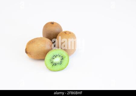 Frutti di kiwi interi e metà isolati su sfondo bianco con spazio di testo Foto Stock