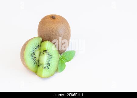 Frutti di kiwi interi e metà isolati su sfondo bianco con spazio di testo Foto Stock