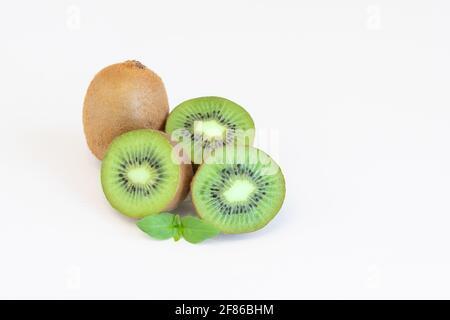 Frutti di kiwi interi e metà isolati su sfondo bianco con spazio di testo Foto Stock