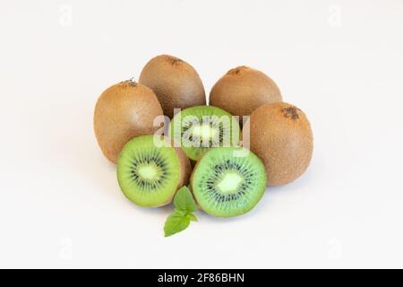 Frutti di kiwi interi e metà isolati su sfondo bianco con spazio di testo Foto Stock