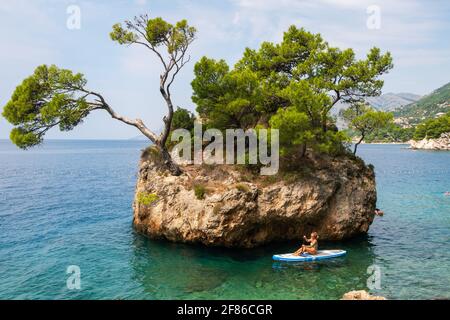 Donna non identificata che cavalcano kayak di mare vicino alla costa croata del mare Adriatico nella Riviera di Makarska, Croazia. Foto Stock