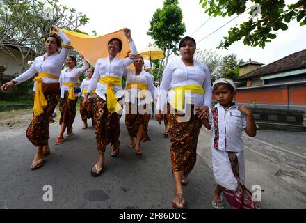 Processione di donne tradizionalmente vestite che portano offerte di templi / gebogani sulla loro testa vicino a Ubud, Bali, Indonesia. Foto Stock