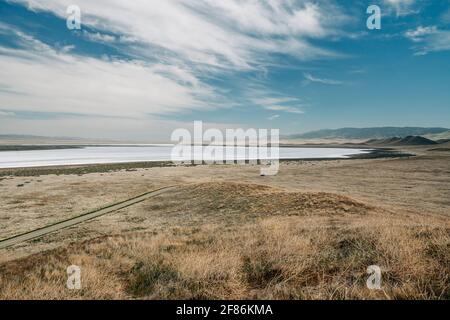 Carrizo Plain National Monument, San Luis Obispo County, California. Lago di Soda, deserto con piante autoctone, colline, montagne e sfondo cielo nuvoloso Foto Stock