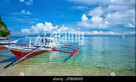 Le tradizionali barche in legno filippino, localmente note come banca, si trovano a Puerto Galera, una località turistica sull'isola di Mindoro, Filippine. Foto Stock