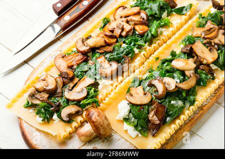 Lasagna con funghi, champagne, formaggio e spinaci. Cucina tradizionale italiana. Foto Stock