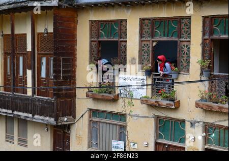 Due Signore che si affaccia da una finestra di una pensione nel villaggio storico Masuleh, Gilan Provincia, Iran Foto Stock