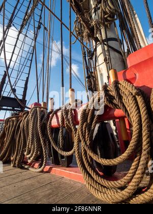 Primo piano delle corde sul ponte della replica della fregata Hermionne (1779 a 1793). Foto Stock