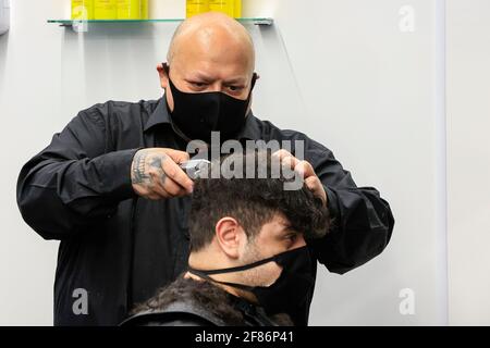 Newcastle upon Tyne, Regno Unito. 12 Aprile 2021. Tommy taglia i capelli di un cliente al negozio Henry Barbershop, High Bridge, Newcastle upon Tyne, in quanto le restrizioni nazionali di blocco sono attenuate in Inghilterra a Newcastle upon Tyne, Inghilterra il 12/04/2021. (Foto di IAM Burn/News Images/Sipa USA) Credit: Sipa USA/Alamy Live News Foto Stock