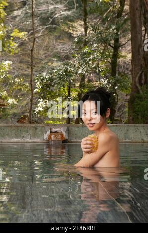 Ritratto bella giovane donna con loofah in piscina termale Foto Stock