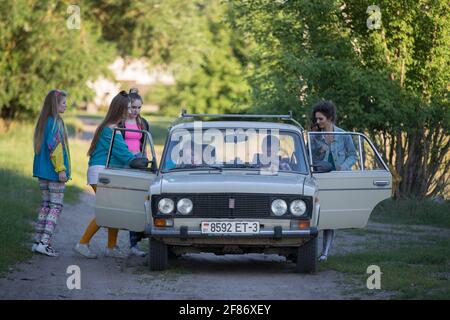 16 07 2020 Bielorussia. Il villaggio di Chkalovo. Un gruppo di ragazze divertenti nello stile degli anni '90 si trova vicino alla vecchia auto. Foto Stock