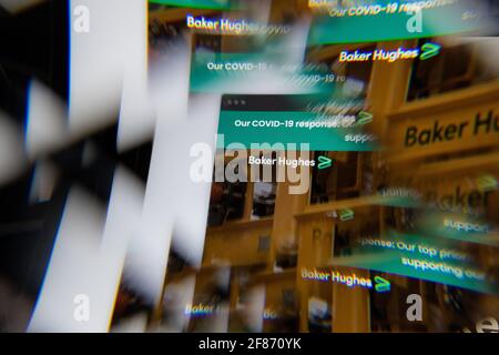 Milano, Italia - 10 APRILE 2021: Logo Baker Hughes Company sullo schermo del laptop visto attraverso un prisma ottico. Immagine editoriale illustrativa di Baker Hughe Foto Stock