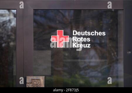 Grenzach-Wyhlen, Baden-Württemberg, Germania - 03.30.2021: Segno di 'Deutsches Rotes Kreuz' sulla porta. Logo della sezione tedesca croce rossa Foto Stock