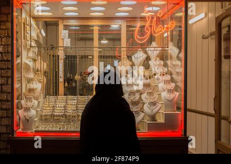 Donna in shador nero guardando il juvenirin una vetrina. Zanjan bazaar, Iran Foto Stock