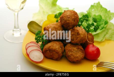 Palle di carne e verdure fresche con vino bianco su giallo piastra Foto Stock