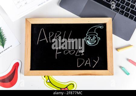 Primo piano di una lavagna con un messaggio 'April Fools Day' su un tavolo da ufficio Foto Stock