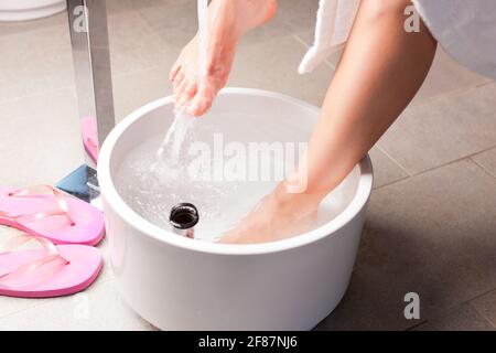 Donna con acqua di idroterapia pediluvio in impostazione spa Foto Stock