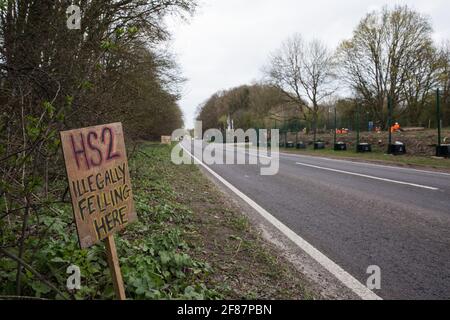 Wendover, Regno Unito. 9 aprile 2021. Un cartello all'esterno di Stop HS2Õs Wendover Active Resistance Camp che si riferisce a un sito sul lato opposto dell'A413 attualmente in fase di eliminazione di alberi e vegetazione da parte di appaltatori che lavorano sul collegamento ferroviario ad alta velocità HS2. Il lavoro di abbattimento degli alberi per il progetto si sta svolgendo in diversi luoghi tra Great Missenden e Wendover nell'AONB di Chilterns, compreso a Jones Hill Wood. Credit: Mark Kerrison/Alamy Live News Foto Stock