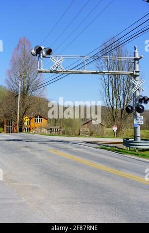 Embreeville, PA, Stati Uniti d'America - 6 aprile 2021: Un attraversamento ferroviario con luci di avvertimento elettriche aeree nella contea rurale di Chester, PA. Foto Stock