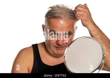 interessato uomo di mezza età con capelli grigi corti su bianco sfondo Foto Stock