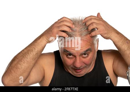 interessato uomo di mezza età con capelli grigi corti su bianco sfondo Foto Stock