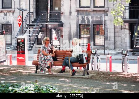Giugno, 2018 - Montreal, Canada: Due donne anziane si siedono sulla panchina in un parco e parlano a Montreal, Canada. Foto Stock