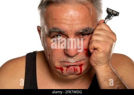 infelice uomo di mezza età con sangue sul viso sfondo bianco Foto Stock