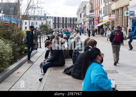 Darlington, Regno Unito. Aprile 12 2021: Gli acquirenti si siedono sulle panchine pubbliche a Darlington in seguito all'ulteriore rilassamento delle regole di blocco nel Regno Unito. Credit: Jason Brown/Alamy Live News Foto Stock