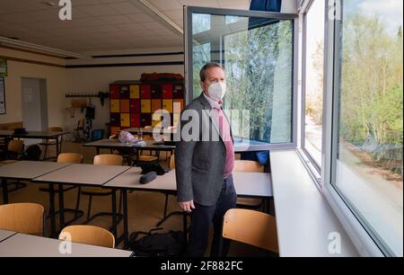 Hildesheim, Germania. 12 Aprile 2021. Rene Mounajed, amministratore delegato della Lower Saxony School Management Association e direttore della Robert Bosch Comprehensive School di Hildesheim, apre le finestre in una classe della sua scuola. L'inizio degli autotest obbligatori Corona per studenti e insegnanti è stato caotico dal punto di vista dell'Associazione di gestione delle scuole della bassa Sassonia. Credit: Julian Stratenschulte/dpa/Alamy Live News Foto Stock