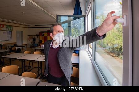 Hildesheim, Germania. 12 Aprile 2021. Rene Mounajed, amministratore delegato della Lower Saxony School Management Association e direttore della Robert Bosch Comprehensive School di Hildesheim, apre le finestre in una classe della sua scuola. L'inizio degli autotest obbligatori Corona per studenti e insegnanti è stato caotico dal punto di vista dell'Associazione di gestione delle scuole della bassa Sassonia. Credit: Julian Stratenschulte/dpa/Alamy Live News Foto Stock