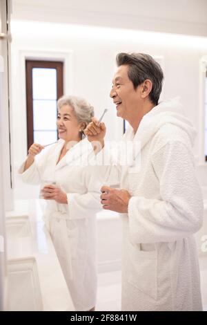 Felice coppia anziana spazzolando i denti in bagno Foto Stock