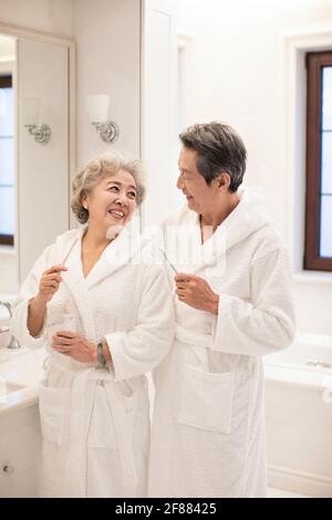 Felice coppia anziana spazzolando i denti in bagno Foto Stock