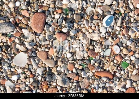 Sfondo e struttura di molte pietre rotonde, tagliate dal mare e adagiate l'una sull'altra, con shards tagliati tra di loro Foto Stock