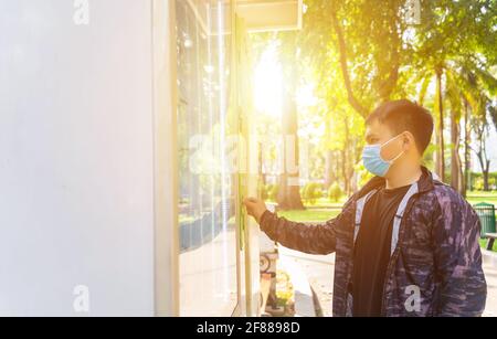 I giovani asiatici pagano le bevande dal distributore automatico. Messa a fuoco selettiva. Foto Stock