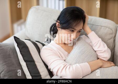 Giovane donna che ha un mal di testa a casa Foto Stock