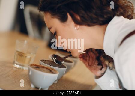 Tazza degustazione ragazza degustazione Degostation caffè prova di qualità. Tazza di caffè. Foto Stock