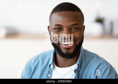 Primo piano Ritratto di giovane allegro bell'uomo afro-americano sorridente Alla fotocamera Foto Stock