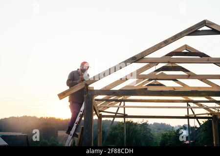 Uomo anziano che acquista legno da costruzione, fai da te che corre in alto sulle scale Foto Stock