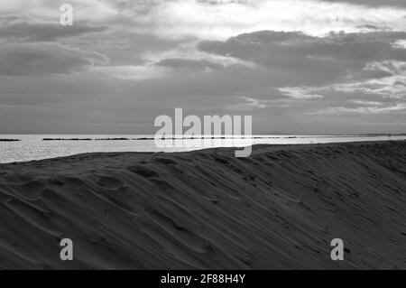 Il Mar Mediterraneo dietro una duna di sabbia al mattino prima di una tempesta (Pesaro, Marche, Italia) Foto Stock