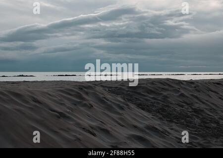 Il Mar Mediterraneo dietro una duna di sabbia al mattino prima di una tempesta (Pesaro, Marche, Italia) Foto Stock