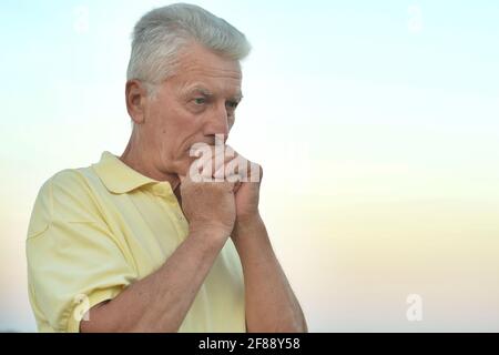 Ritratto di pensosa senior uomo nel parco di autunno Foto Stock