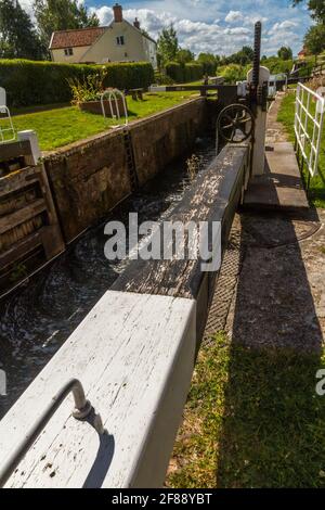 Pittoresca chiusa di canale nel Regno Unito nella soleggiata giornata estiva. Taunton e Bridgewater Canal, Maunsel Lock, Regno Unito, grandangolo, ritratto. Foto Stock