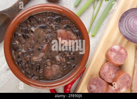 Tradizionale feijoada brasiliana in una ciotola con ingredienti. Foto Stock