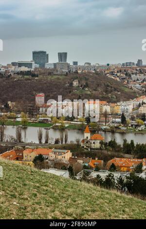 Vecchie case, piccola chiesa con tetto rosso, moderno grattacielo di vetro nel retro, Praga, ceco republic.Real estate residenziale concept.Czech architettura Foto Stock