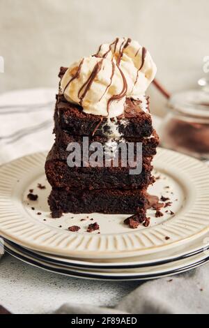 Shot verticale di Brownies preparati con gelato in cima a un tavolo Foto Stock