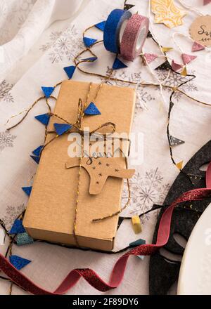 Confezione regalo di Natale legata con nastro dorato e una ghirlanda blu. Il nome Sean è sul tag. Foto Stock