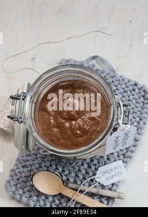 Vista closeup di un vaso di mousse al cioccolato isolato su un tovagliolo lavorato blu accanto a un paio di cucchiai. Foto Stock