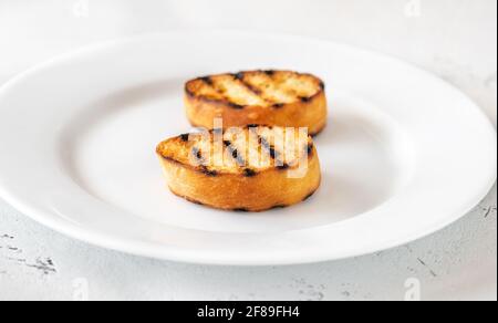 Fette di pane tostato sul piatto da portata Foto Stock