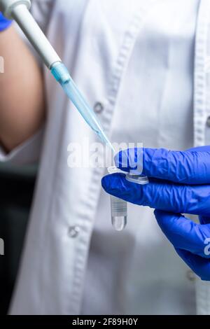 mano di un paramedico con una provetta sullo sfondo bianco. Foto Stock