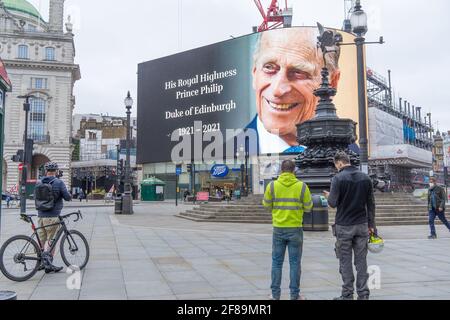 Gli schermi giganti di Piccadilly Circus che ripagano rispetto a sua altezza reale il principe Filippo il duca di Edimburgo come annuncio della sua morte. Londe Foto Stock