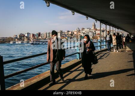 Istanbul, Turchia. 12 Aprile 2021. Le persone che indossano maschere sono viste camminare lungo il sottopassaggio del Ponte di Galata a Istanbul. Il presidente Erdogan dovrebbe annunciare le nuove misure del coronavirus da attuare durante il mese di Ramadan che inizierà domani. Credit: Hakan AKGUN/SOPA Images/ZUMA Wire/Alamy Live News Foto Stock